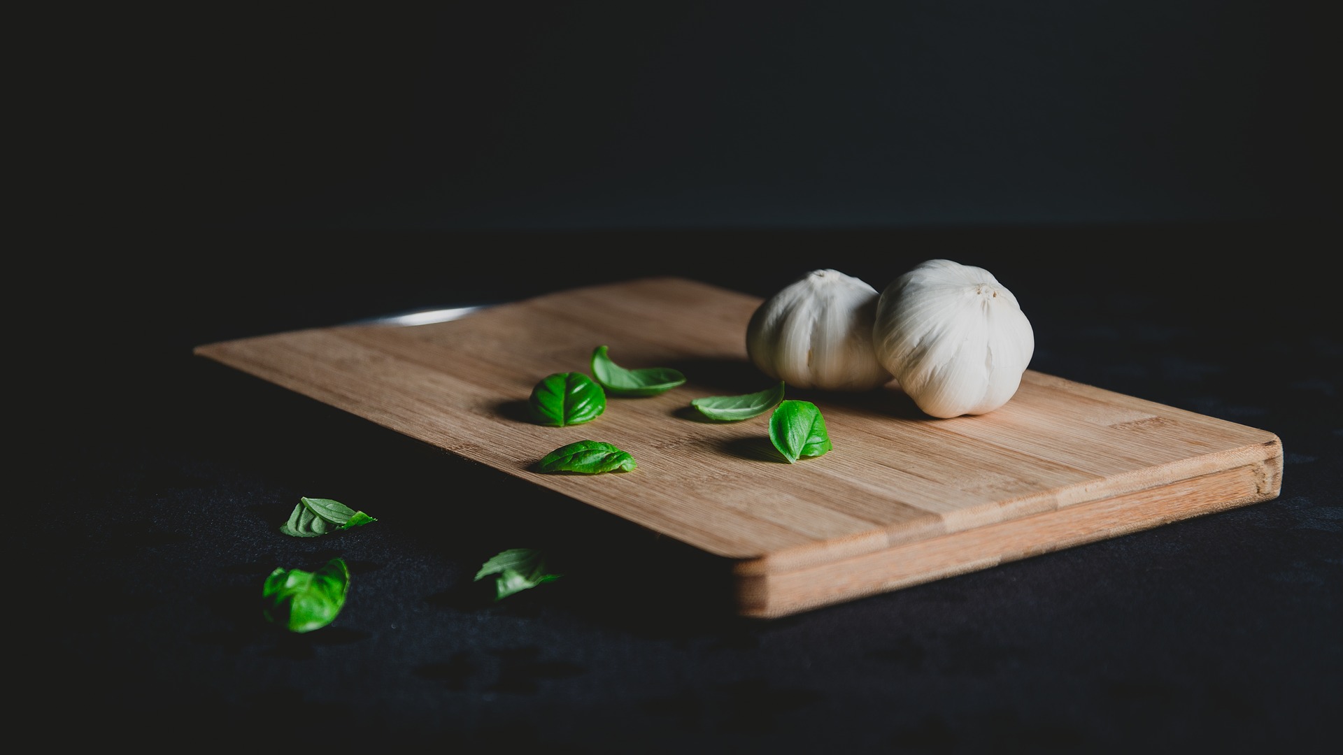 chopping board with garlic and basil